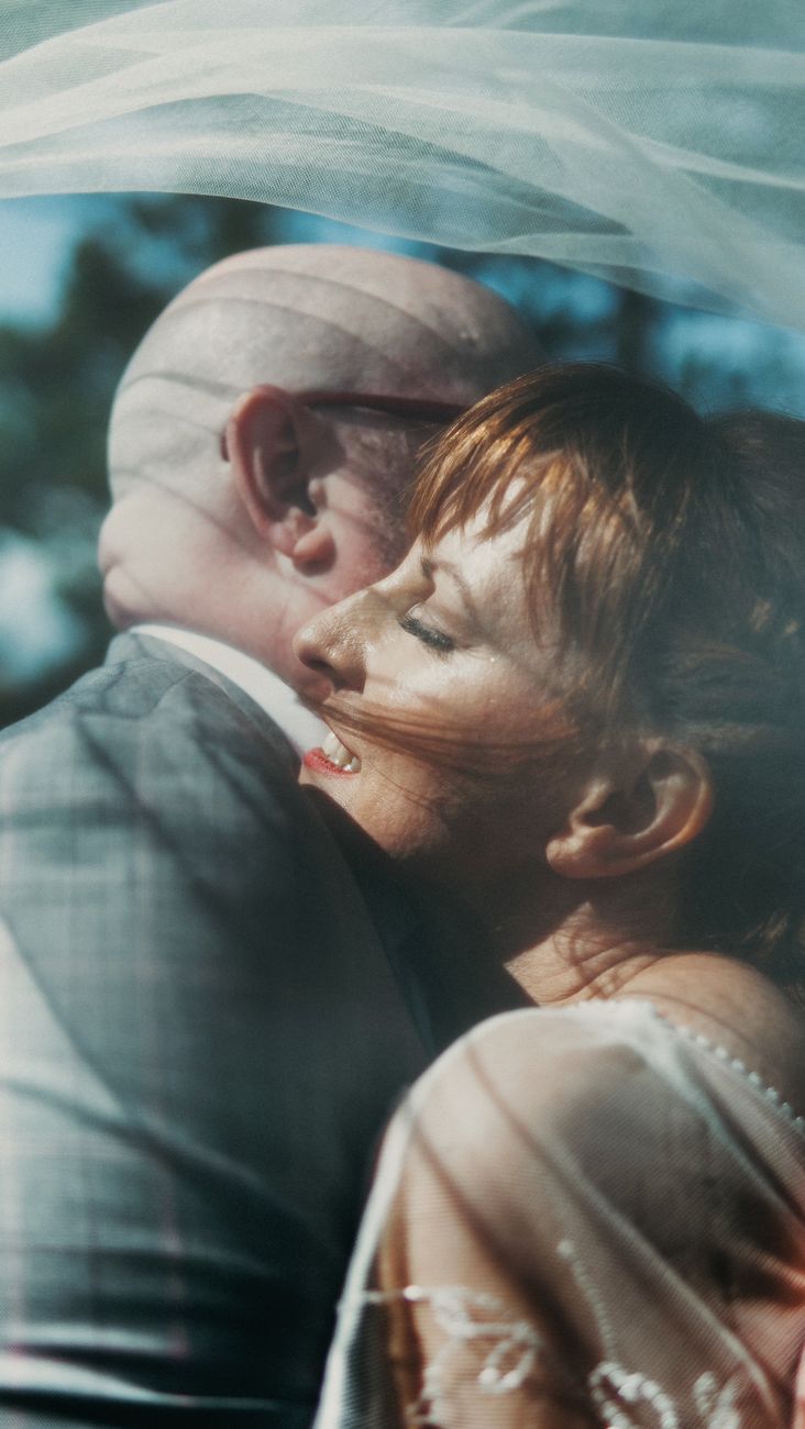 A touching moment between a couple on their wedding day outdoors.